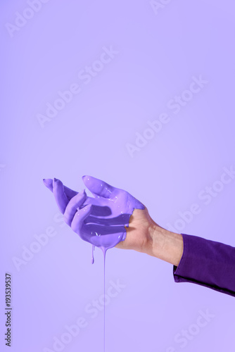 cropped view on female hand in purple paint, ultra violet trend of 2018 year