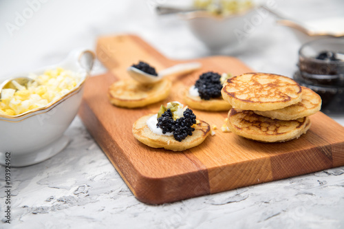 Deutscher Kaviar auf Perlmutt Löffel mit Blinis, gehackte Eier, Saure Sahne und Gurkenrelish