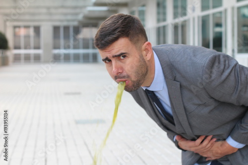 Overworked businessman vomiting at work 