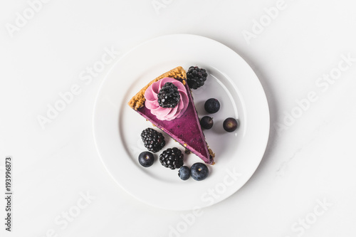 top view of blueberry cake with fresh berries on plate isolated on white