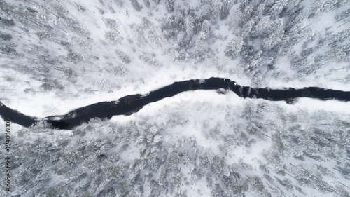 Aerial view of river bend and boreal forest covered by snow