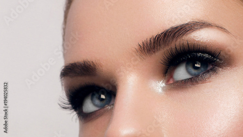 Macro shot of woman's beautiful eye with extremely long eyelashes. Sexy view, sensual look. Female eye with long eyelashes