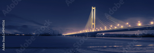 Panoramic night view of the city and the bridge in the lights. black and white toned picture