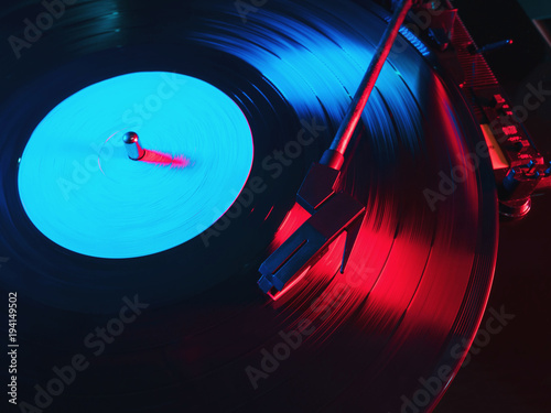 Cinemagraph, retro record vinyl player. Record on turntable. Top view close up. Loop-able Vintage photo of Old Gramophone, playing a music. Neon light