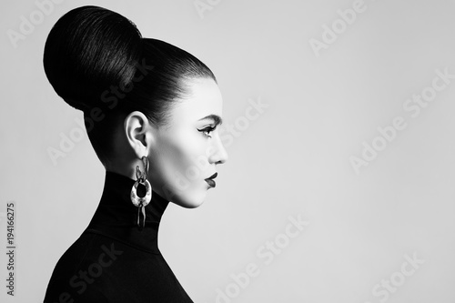 Retro style black and white fashion portrait of elegant female model with hair bun hairstyle and eyeliner makeup