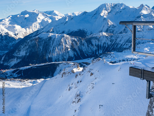 Gondola lift cabin of ski-lift in the ski resort in the early morning at dawn with mountain peak in the distance. Winter snowboard and skiing concept. France, Courchevel, 2018