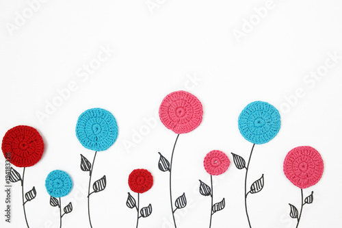 knitted flowers on a white background. view from above. children's background