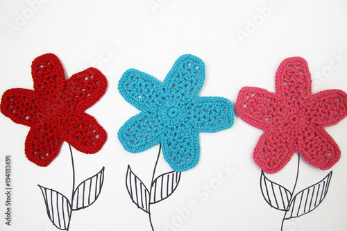 knitted flowers on a white background. view from above. children's background