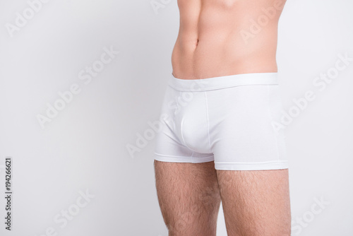 Masculinity nude people person abs pecs model fashion concept. Cropped close up photo of man's strong muscular legs wearing white classic boxer-shorts isolated on gray background copy-space cutout