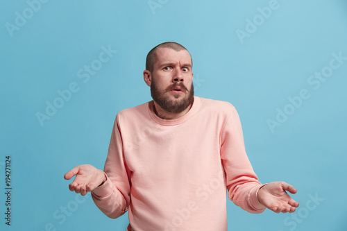 Beautiful man looking suprised and bewildered isolated on blue