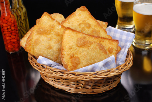 Brazilian typical pastry called pastel in black pub table background 