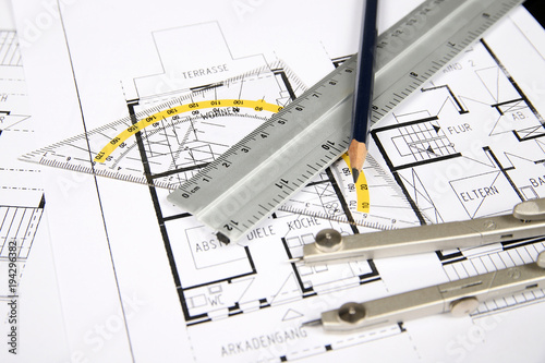 Lineal, Zirkel und Bleistift liegen auf einem Grundriss