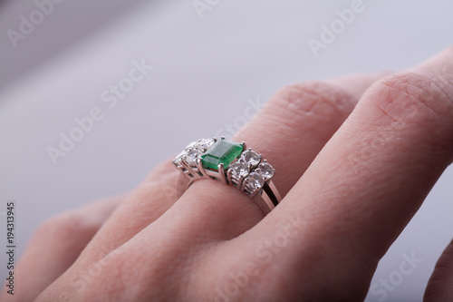 Dedo corazón con anillo de esmeralda y diamantes