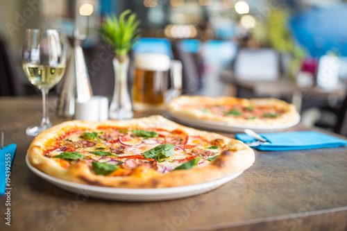 The served dinner table with pizza in pizzeria or restaurant.