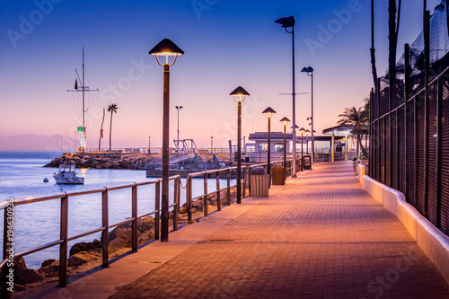 Brick walkway to boat dock in early sunrise light, streelights on, shadows, quiet, calm peaceful, Avalon, Santa Catalina Island, California