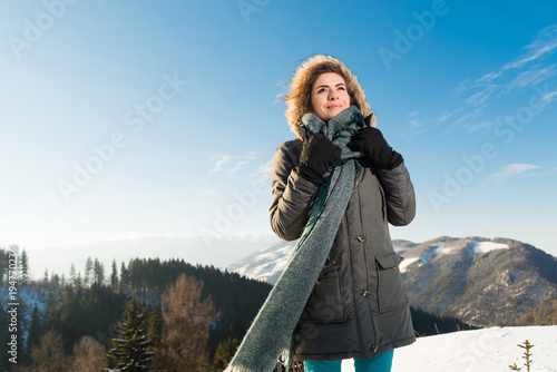Beautiful girl outdoor in cold snowy winter, looking playful 