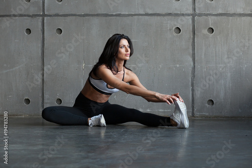 athletic brunette woman stretching legs