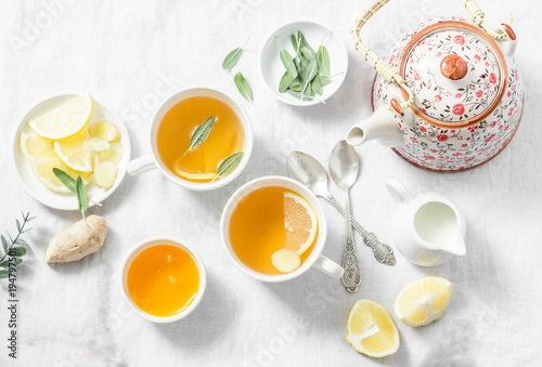 Cough tea. Green tea with lemon, ginger, sage on a light background, top view. Healthy detox drink. Flat lay