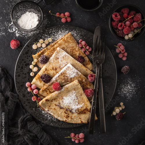 crepes with frozen berries and powdered sugar