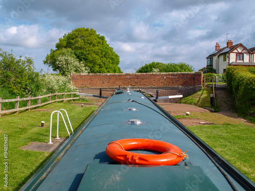 Helmsman view of a narrowboat in a canal lock in the upper position befor discharching the lock chamber. Picture taken on the Shropshire Union Canal near Audlem in Cheshire, England.
