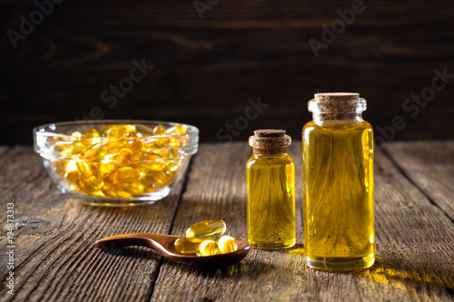 Fish oil capsules on wooden background, vitamin D supplement