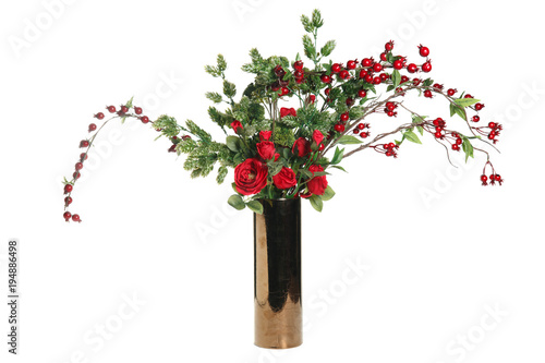 Bouquet of artificial red roses and hips of wild rose in a golden vase isolated on white background.