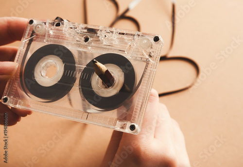 Vintage cassette and pencil to rewind tape on brown background