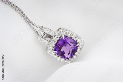 White gold pendant with rose violet amethyst and diamonds on soft blurred background
