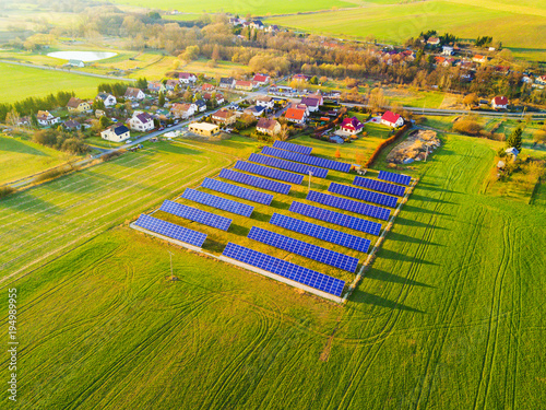 Aerial view of solar power plant. Photovoltaic power station supplying electricity to small town in countryside. Renewable solar energy in the city.