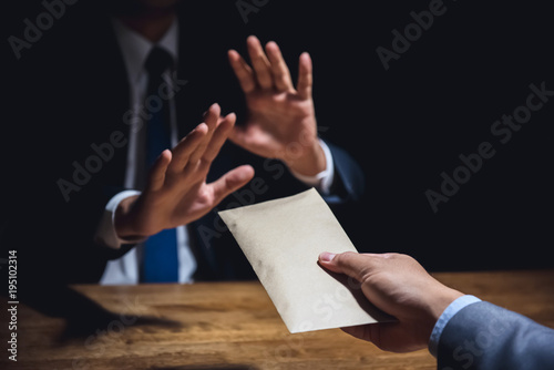 Businessman rejecting money in the envelope, anti bribery concept