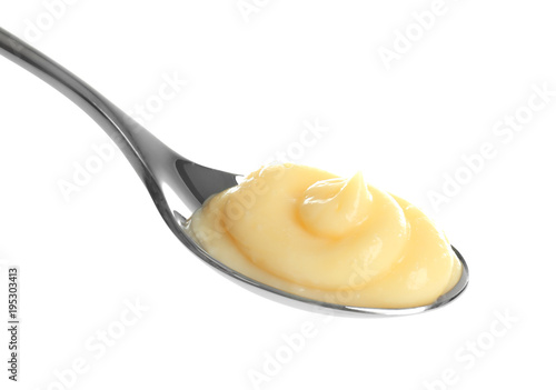 Tasty vanilla pudding in spoon on white background