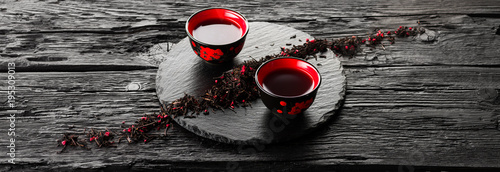 Cups of tea on slate plate on a black wooden table