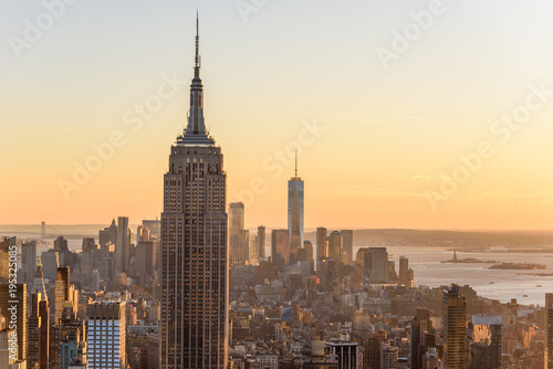 New York City - USA. View to Lower Manhattan downtown skyline with famous Empire State Building and One World Center and skyscrapers at sunset.