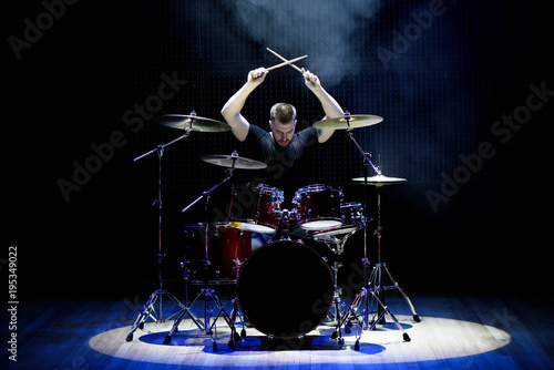 Drummer playing the drums with smoke and powder in the background