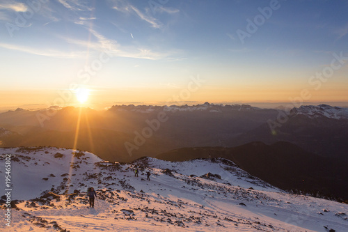 Tourists climb the mountain at the sunset in the French Alps