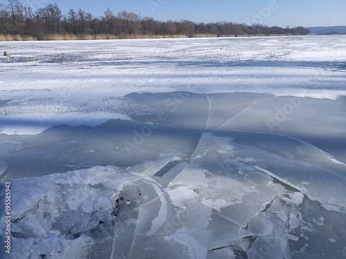 Kruchy, spękany lód na rzece.