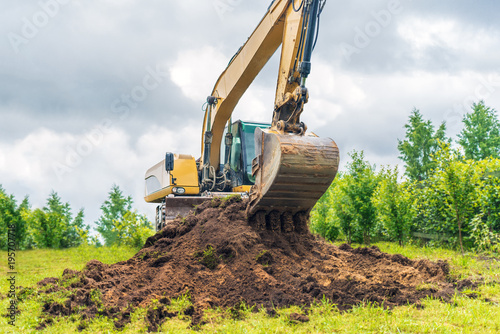 Excavator removes the grass layer