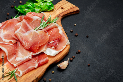 Italian prosciutto crudo or spanish jamon. Raw ham on wooden cutting board