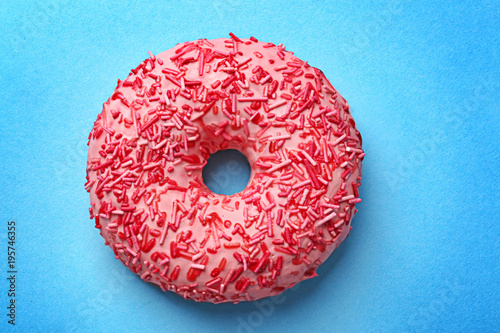 Delicious pink donut on color background