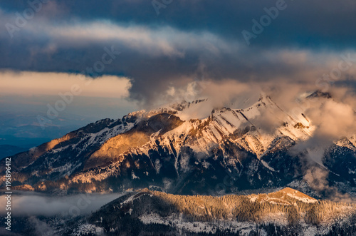 panorama of snowy Tatra Mountains in clouds, poland