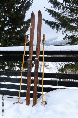 Photo of vintage old wooden skis on the terrace of a country house