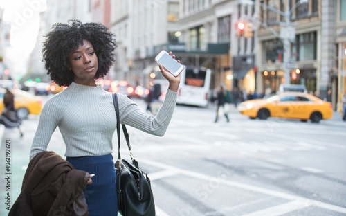 Woman with mobile device waiting for rideshare car service