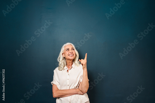 Mature old beautiful woman pointing showing copyspace