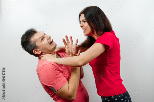 A family quarrel, his wife scolds her husband, a young, beautiful wife strangling her husband. The concept of the psychology of family relations, marriage, domestic conflicts, domestic violence.