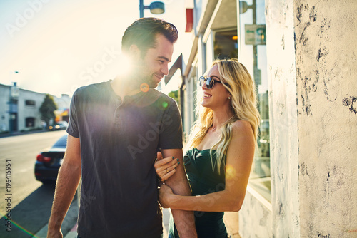 flirty romantic couple walking together on los angeles sidewalk