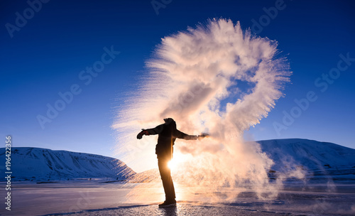 boiling water frost in polar arctic sky in Norway Svalbard in Longyearbyen man mountains