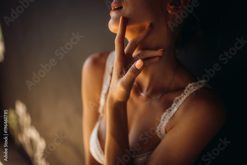 Woman in white lingerie touches her neck tender