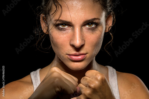 Intense female fighter stare with fist up in self defense training, powerful and confident