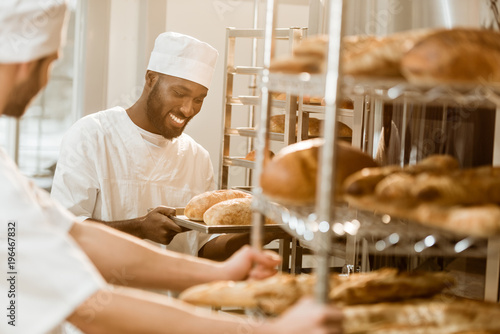 handsome bakers working together at baking manufacture