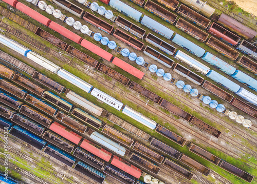 Kolorowe wagony kolejowe widziane z powietrza. Wagony kolejowe ustawione w szeregu na równoległych torach. 